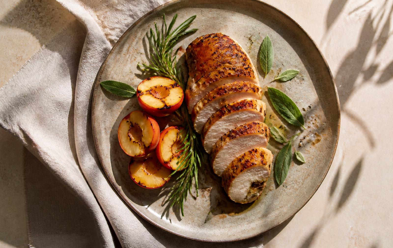 Pechuga de pollo asada con romero, melocotón a la parrilla y salvia sobre plato de piedra